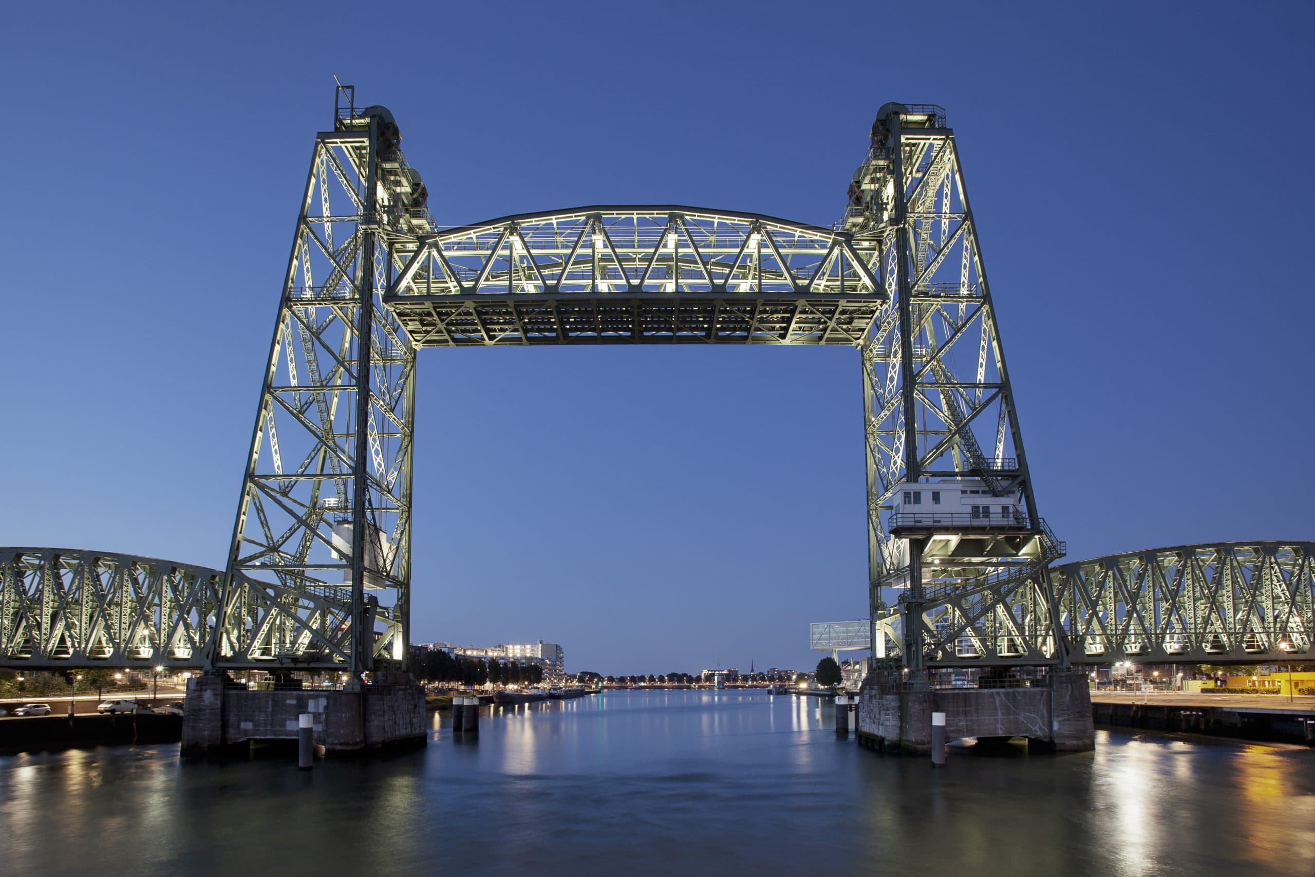 De Hef, de geheven spoorbrug over de Nieuwe Maas in Rotterdam, verlicht in de avondschemering