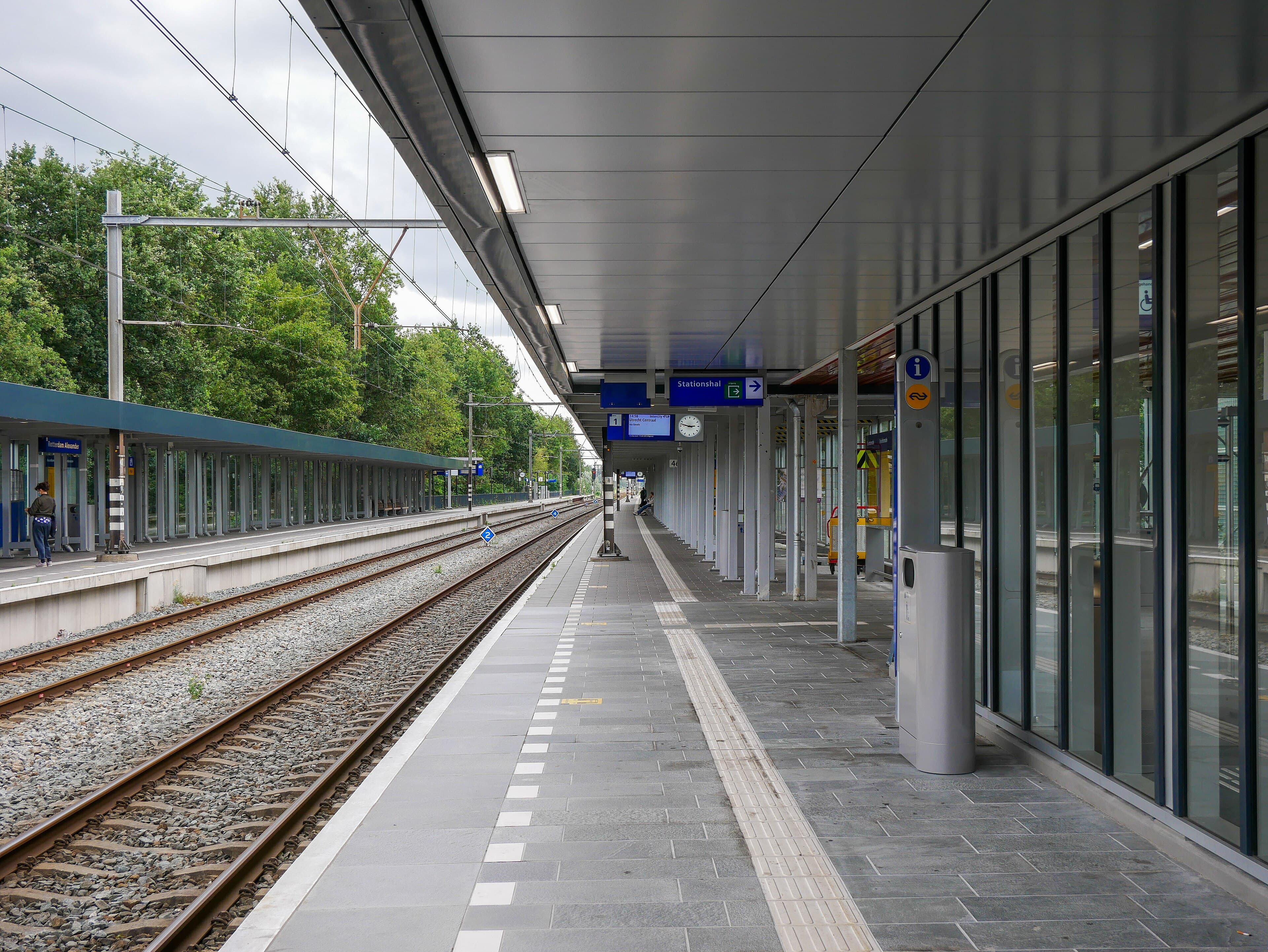 Een leeg perron met overkapping en spoor op station Rotterdam Alexander