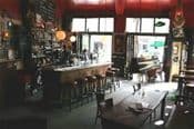 Interieur van een bruin café met bar en houten tafels